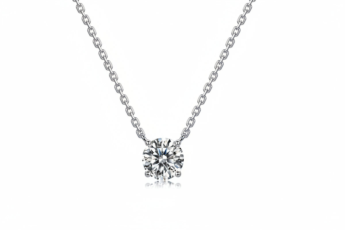 A silver solitaire necklace with a round brilliant-cut diamond pendant.