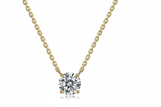A yellow gold necklace with a round-cut clear gemstone pendant, shown on a white background