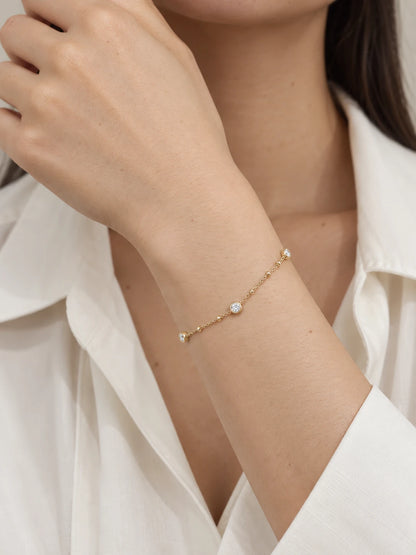 Nyla gold bracelet worn close-up showing three petite round bezel stone stations and small gold accents between them